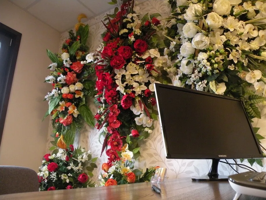 Bureau d'accueil de l'agence décoré de grandes compositions florales artificielles colorées