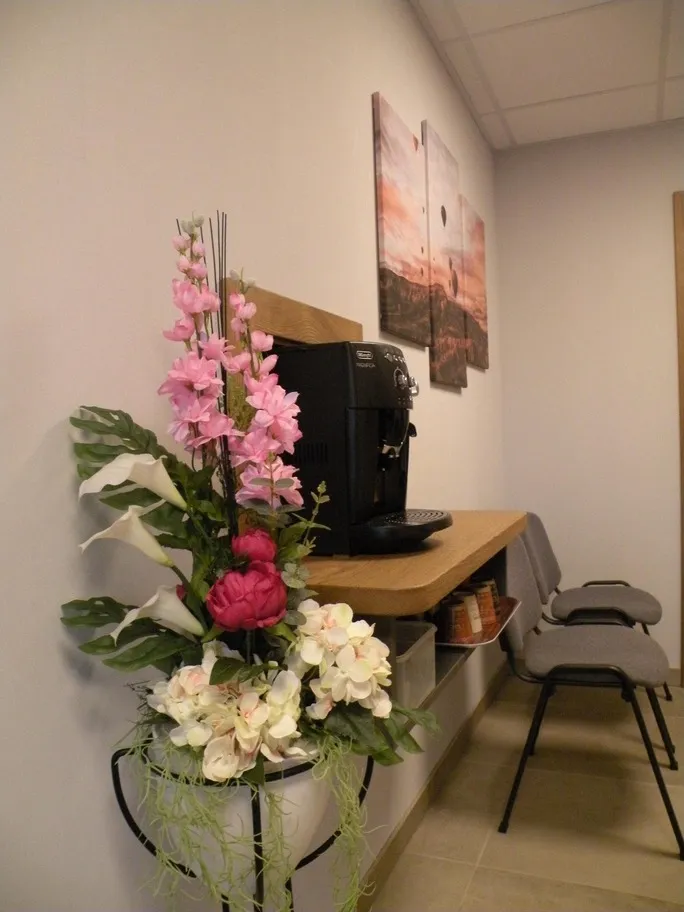 Espace d'attente convivial dans la chambre funéraire avec machine à café et décoration florale